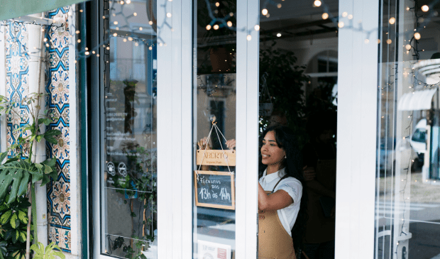 Female shopkeeper unlocking store door
